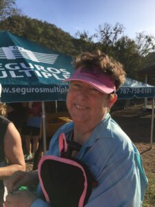 woman wearing pink visor and smiling