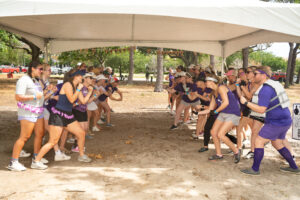 Two lines of people with their fists up and ready to compete at 2024 Dragon Boat Festival