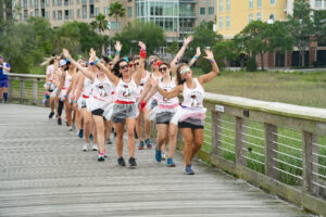 Group of women dancing and singing down the dock at 2024 Dragon Boat Fesitval