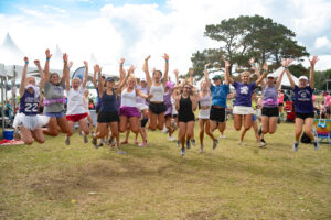 Group of women wearing purple and jumping in the air