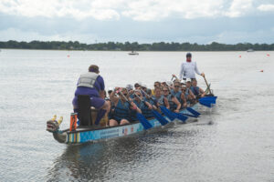 Dragon boat group with blue life jackets in the water