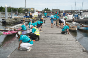 Group of people on the dock preparing their boats to race