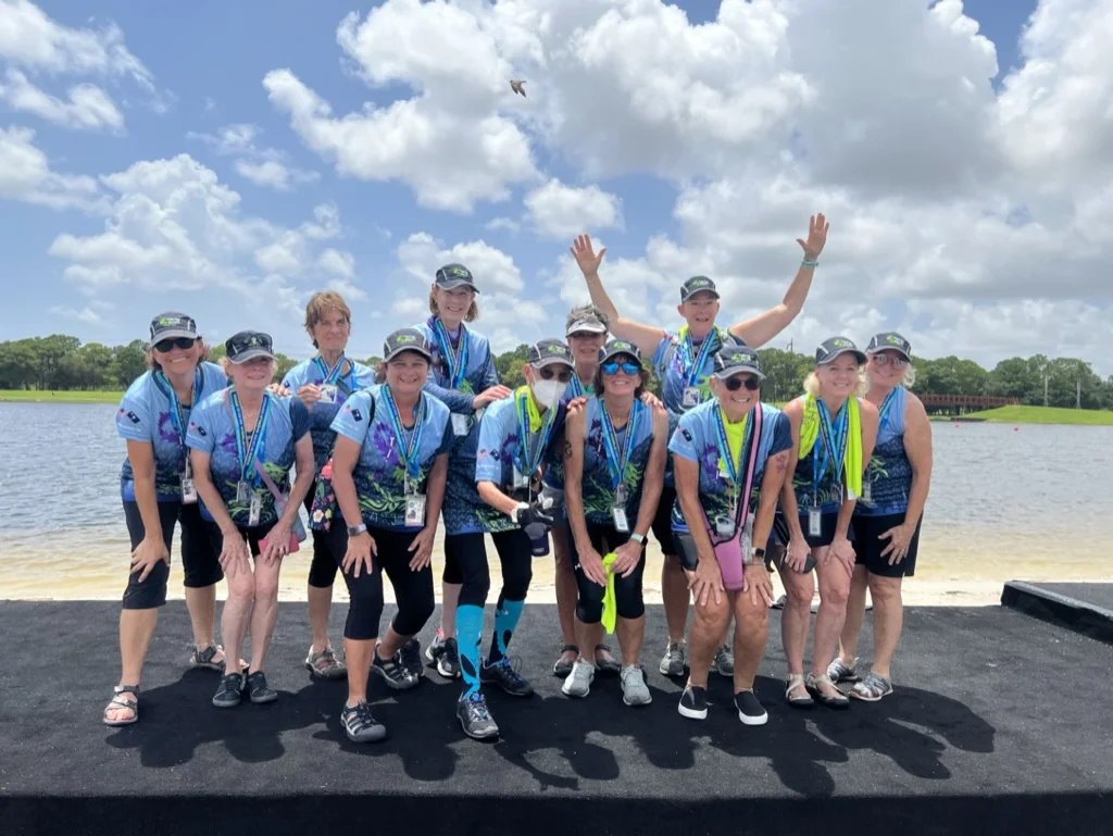 Group on dock wearing matching shirts and medals
